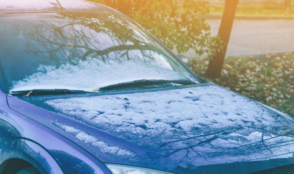 ice and hail on dented hood of car